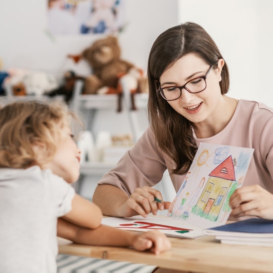 A child talks to a woman about a picture