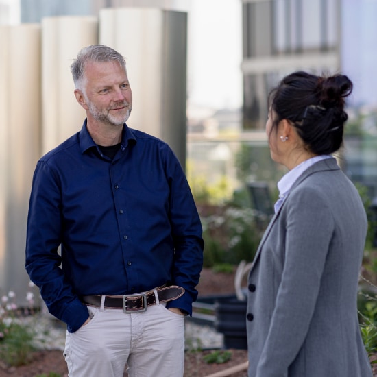 Photograph of two employees chatting on the terrace