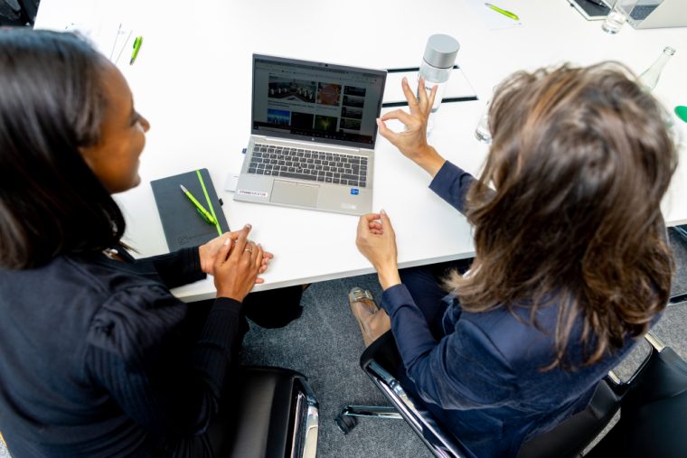 Two colleagues sitting in front of a laptop