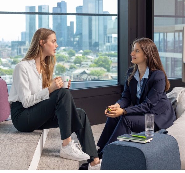 Two employees sitting in a room with a view of the skyline